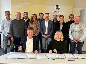 Landrat Dr. Ulli Schäfer und Katrin Dix, Kreisvorsitzende des Gemeinde- und Städtebundes Greiz, unterzeichnen beim Kommunalen Arbeitskreis mit Bürgermeistern und Vorsitzenden der Verwaltungsgemeinschaften des Landkreises Greiz den Brief an Bundesfinanzminister Lars Klingbeil.