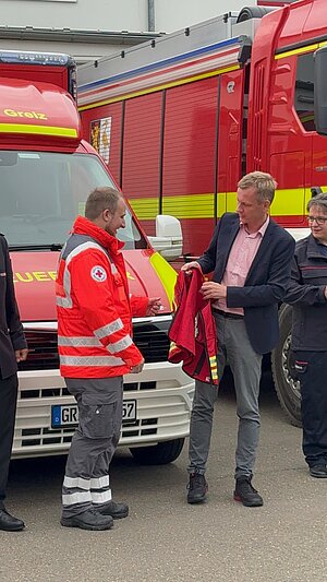 Landrat Dr. Ulli Schäfer übergibt die neuen Kennzeichnungswesten (Quelle: LRA Greiz/Ramona Jung).